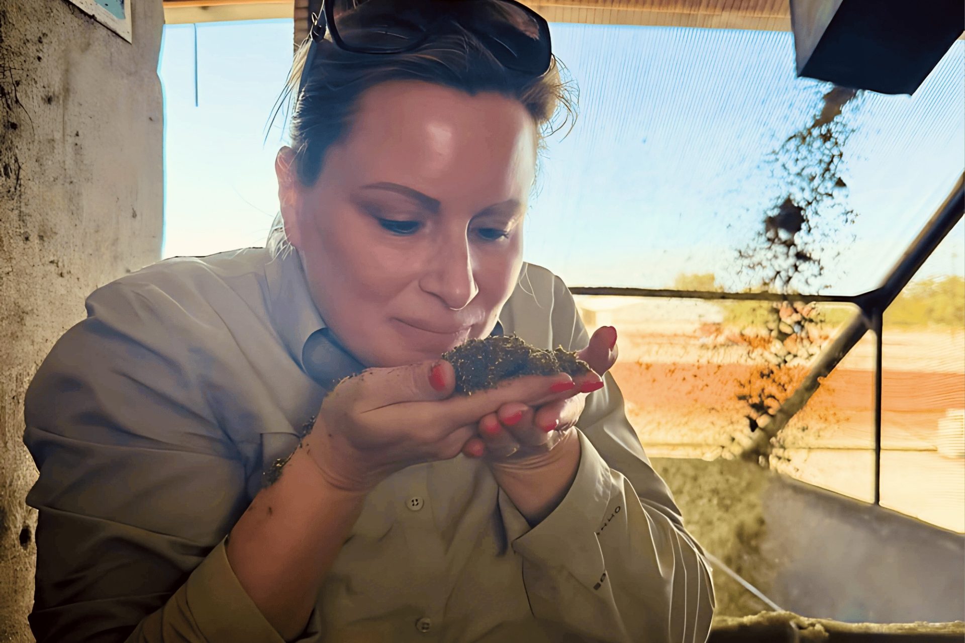 Heleen ruikt aan een handvol vers verwerkte rooibos in de toetskamer.